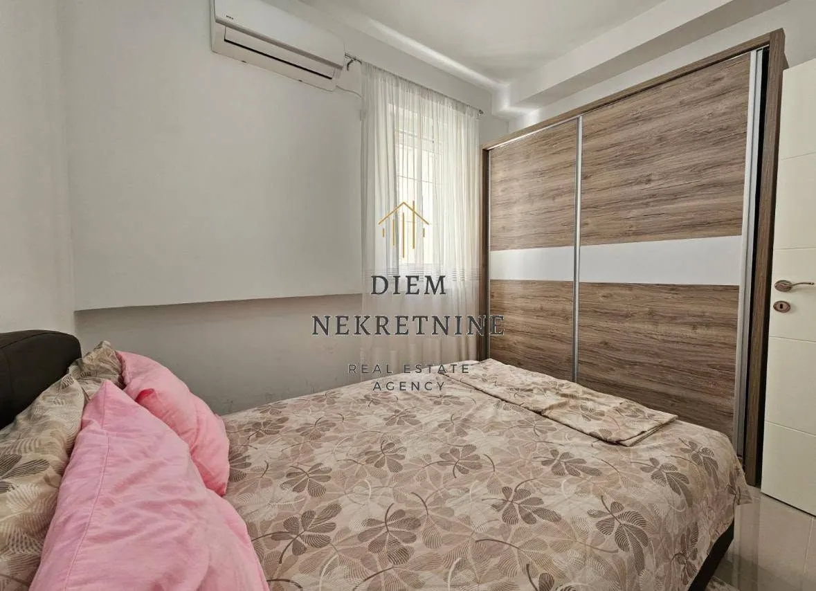 Furnished bedroom with a double bed and a large wardrobe.