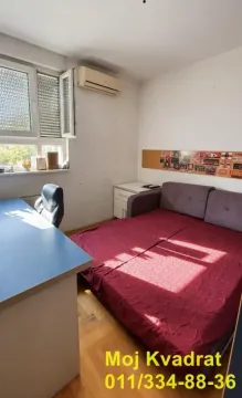 Manja spavaća soba sa krevetom, radnim stolom i klima uređajem. - image 7