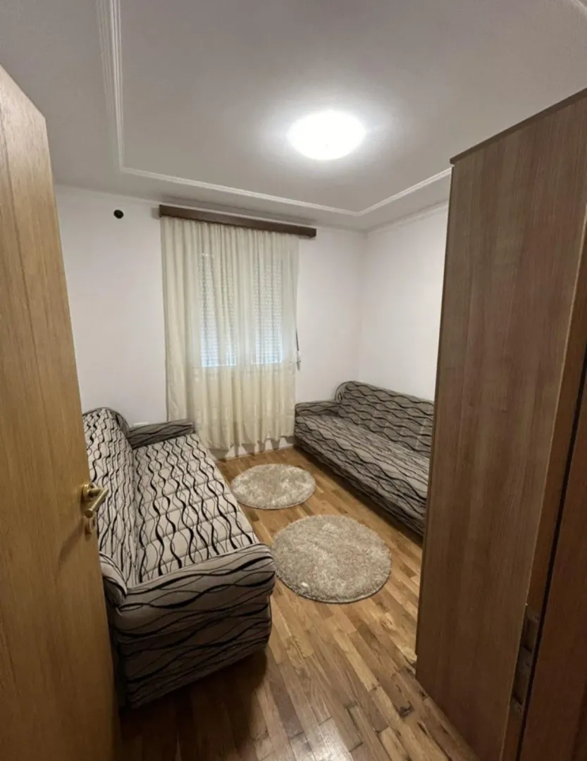 Smaller living room with seating furniture and parquet flooring.