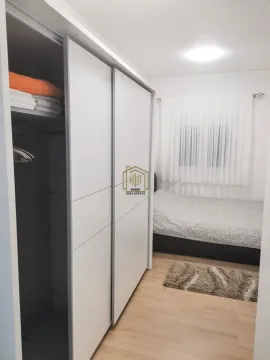 Furnished bedroom with a large white wardrobe and a bed. - image 8