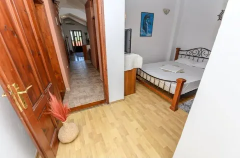 View from the hallway into a bedroom with a bed and laminate flooring. - image 9