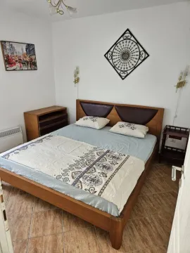Namještena spavaća soba sa bračnim krevetom i drvenim komadom namještaja. - image 3