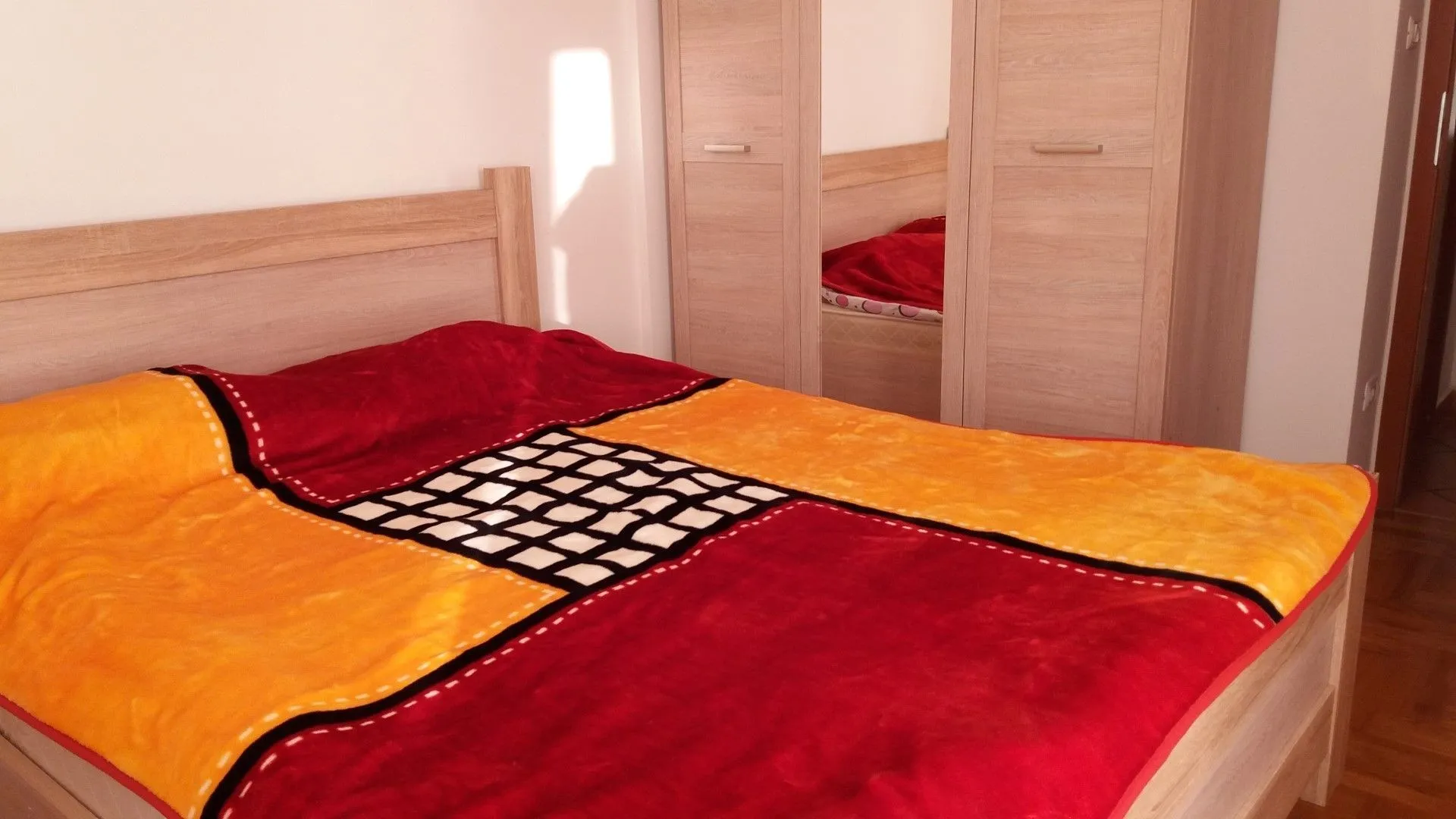 Bedroom featuring a double bed and a wooden wardrobe.