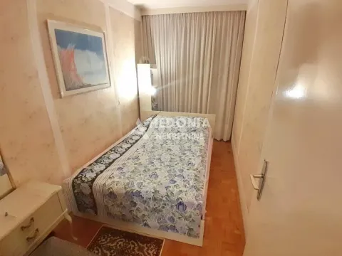 Manja spavaća soba sa krevetom, noćnim stočićem i tapetama na zidovima. - image 7