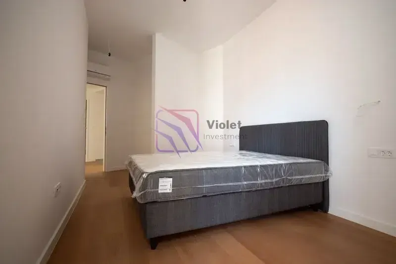 Spavaća soba sa bračnim krevetom i drvenim podom.