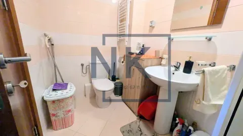Small bathroom with a sink, toilet, and light-toned tiles. - image 12