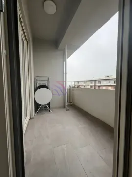 Nakatkriveni balkon sa popločanim podom i odloženim nameštajem. - image 3