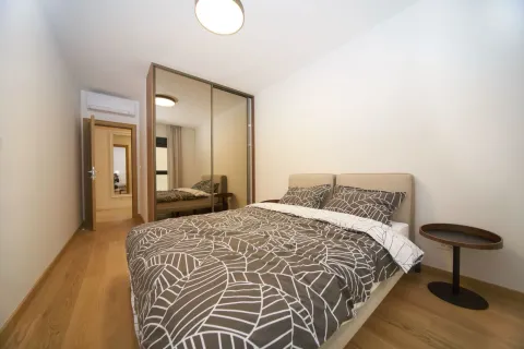Bedroom with a double bed, a large mirrored wardrobe, and hardwood flooring. - image 4