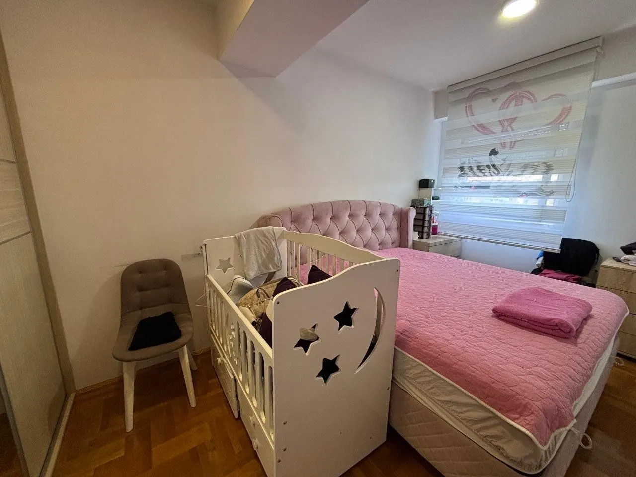 Dječija soba sa krevetom za odrasle i krevetcem.