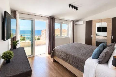 Bright bedroom with a double bed, wardrobe, and access to a terrace with a sea view. - image 7