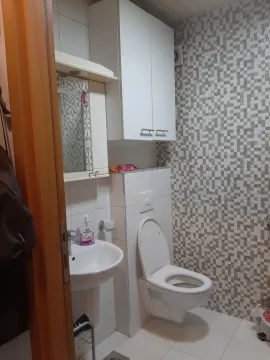 A small bathroom with a sink, cabinet, and toilet. - image 15