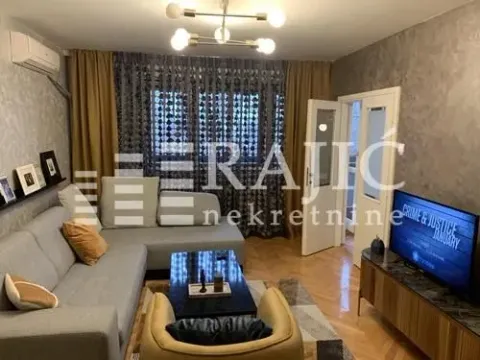 Nameštena dnevna soba sa ugaonom garniturom i televizorom. - image 3