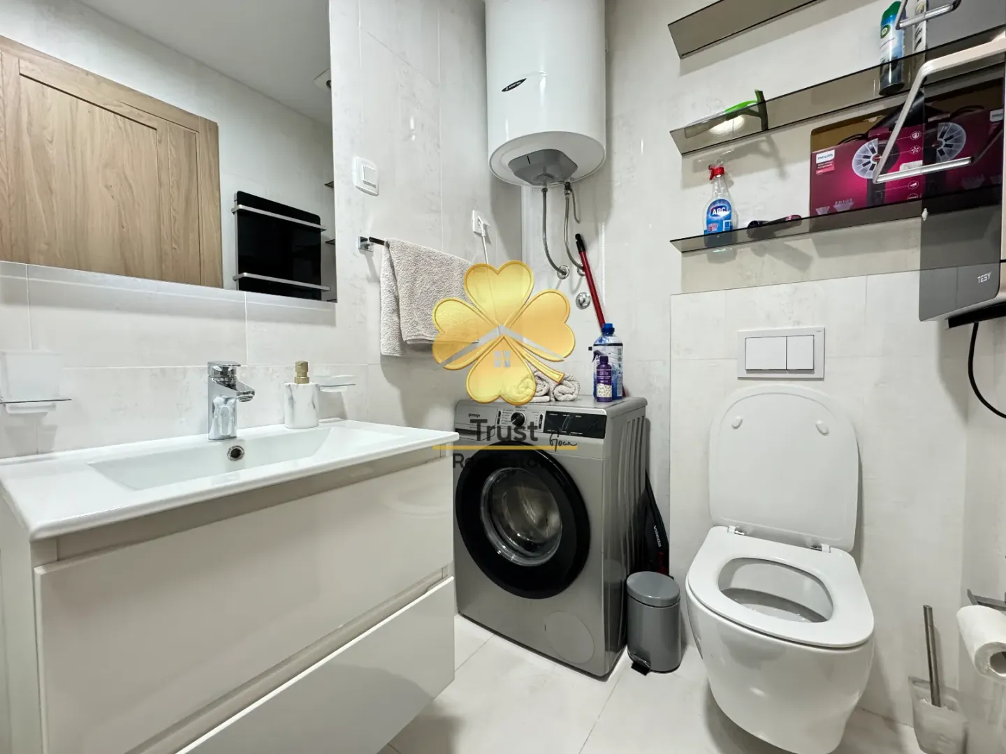 Small bathroom with a sink, toilet, and washing machine.