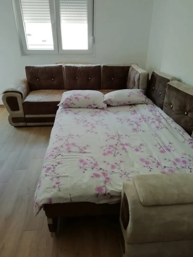 Dnevna soba sa ugaonom garniturom koja se može koristiti kao krevet.