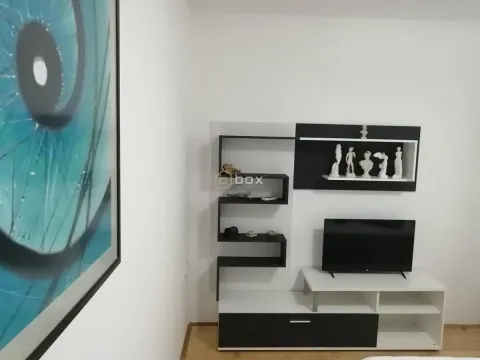 Living room with a television and wall shelves. - image 3