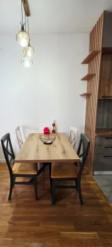 Trpezarija sa drvenim stolom, stolicama i modernim osvjetljenjem. - image 13