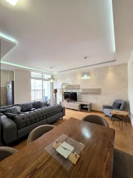 Spacious living room with a sofa set, TV, and dining table. - image 16