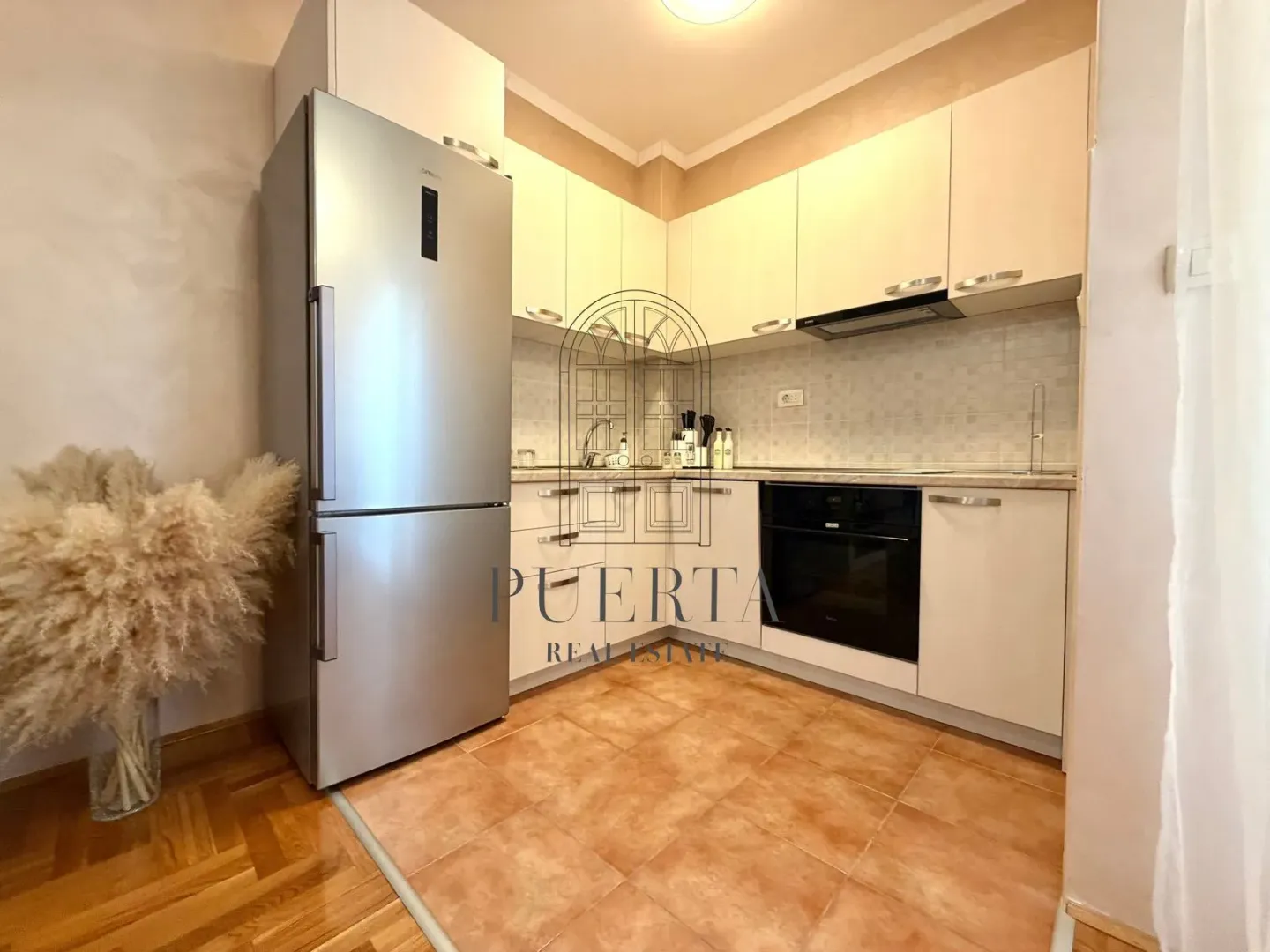 Small kitchen with light cabinets and built-in appliances.