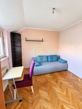 Manja dnevna soba sa kaučem, radnim stolom i drvenim podom. - image 5