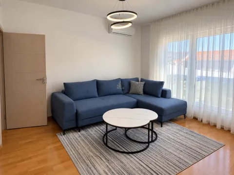Living room with a blue sectional sofa, coffee table, and access to the terrace. - image 2
