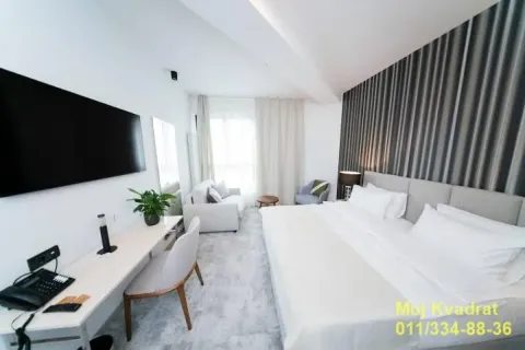 Spacious bedroom with a double bed, desk, and sofa. - image 2