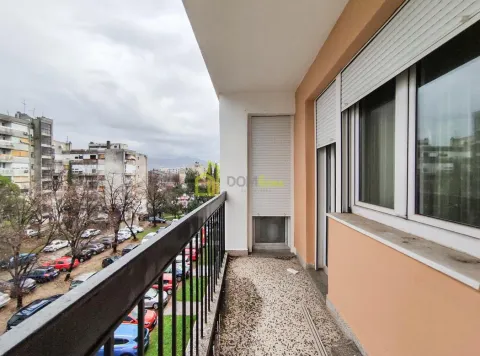 Dugački balkon sa metalnom ogradom i pogledom na grad. - image 11