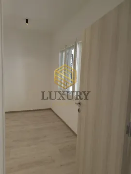 Empty room with light laminate flooring and an open door. - image 12