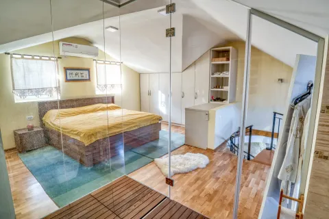 Attic bedroom with a double bed, built-in wardrobes, and a glass partition. - image 11