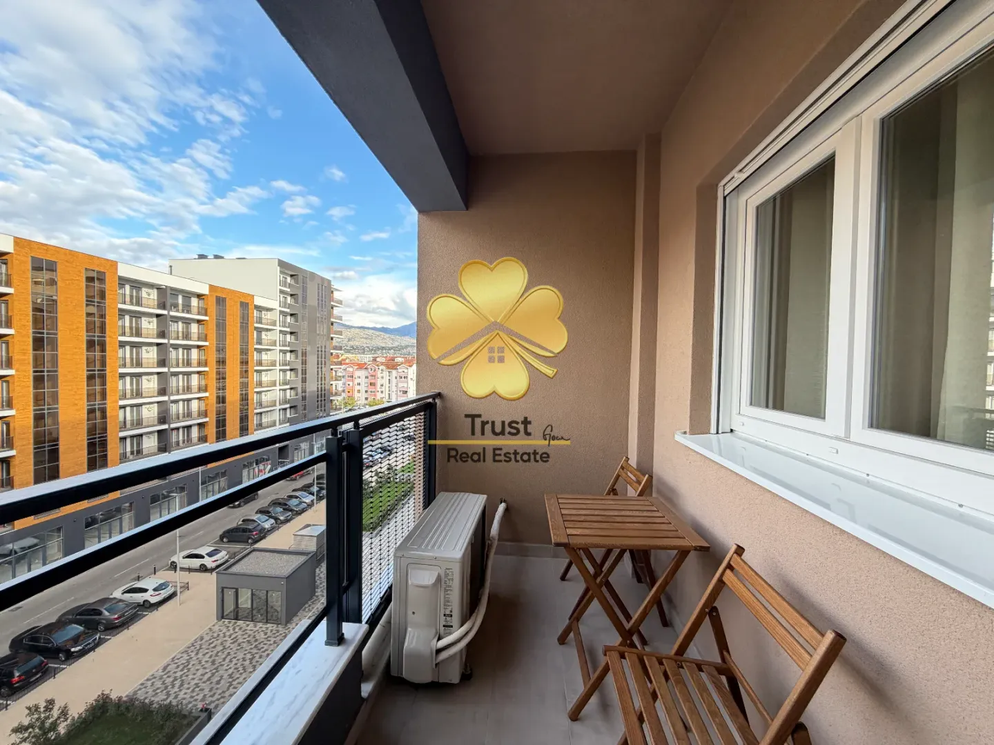 Furnished balcony with seating set and city view.