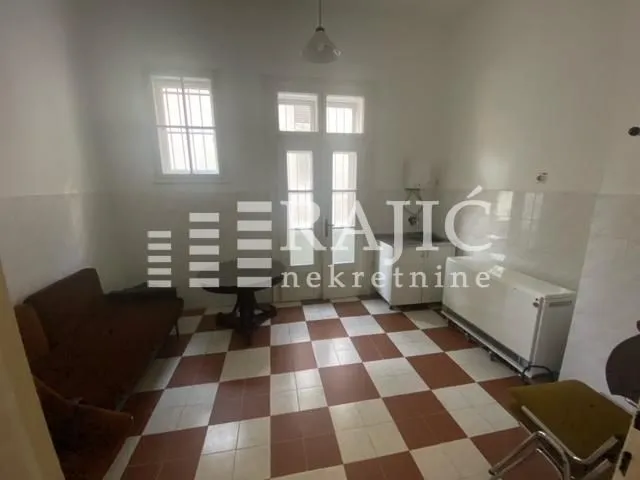 Living room with a dining table and kitchen units.