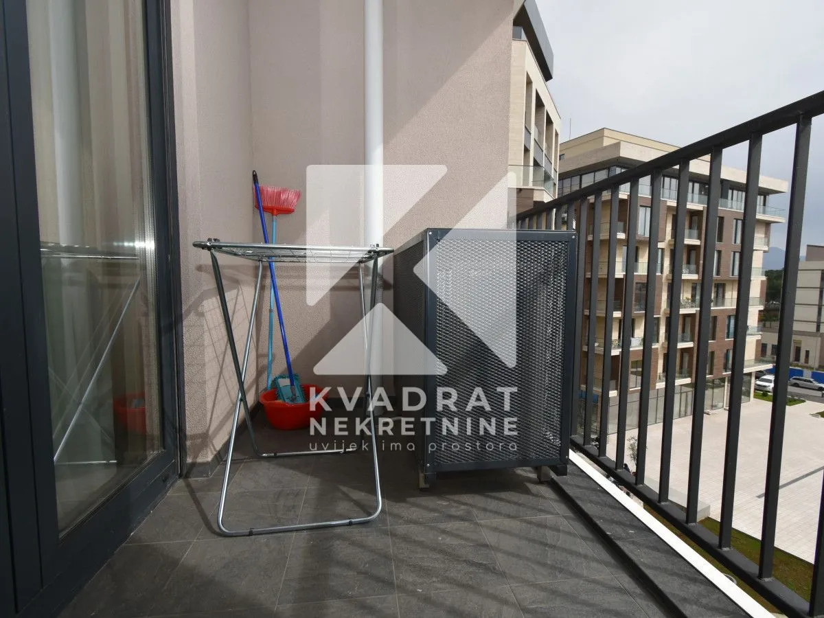 Balcony with a clothes drying rack and an air conditioner unit.