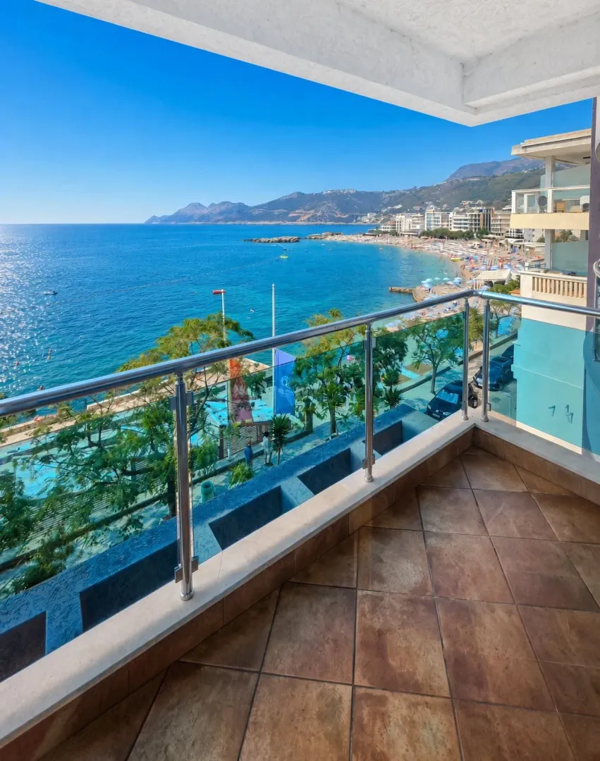 Balkon sa popločanim podom i pogledom na more i plažu.