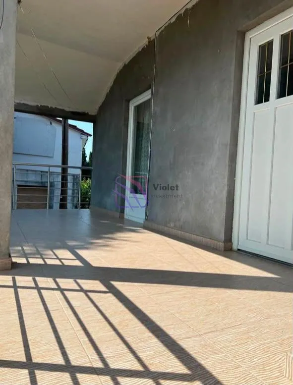 Covered terrace with tiled flooring and an entrance to the building.