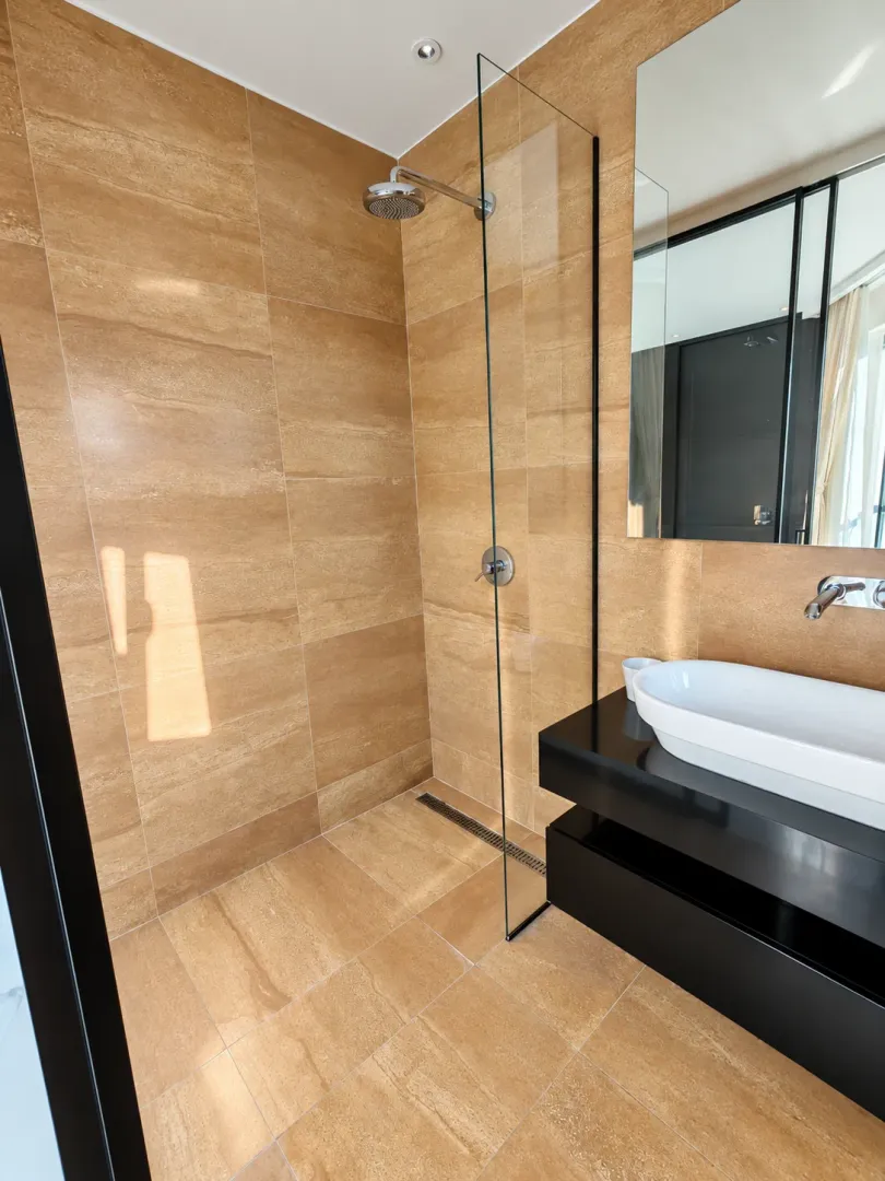 Modern bathroom with a shower cabin and a washbasin.