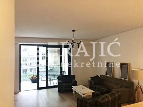 Spacious living room with seating set and terrace access.