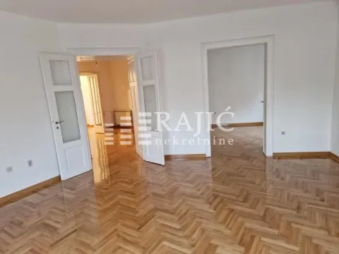 Empty room with hardwood flooring and white walls, featuring doors leading to other rooms. - image 8