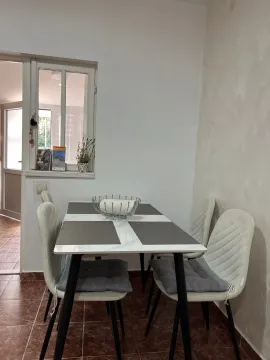 Dining area with a table and white chairs. - image 8