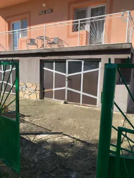 Yard of the house with garage doors and a balcony on the upper floor. - image 2