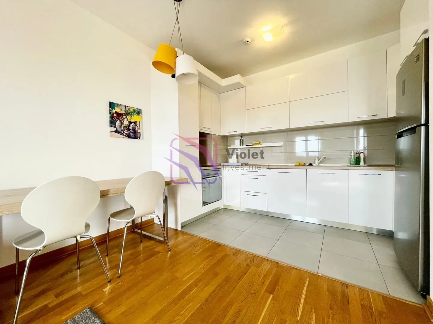 Modern white kitchen with a dining area.