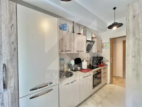 Compact kitchen with wooden cabinets and built-in appliances. - image 4