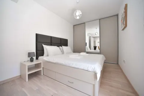 Modern bedroom with a double bed, bedside table, and a built-in wardrobe with a mirror. - image 12