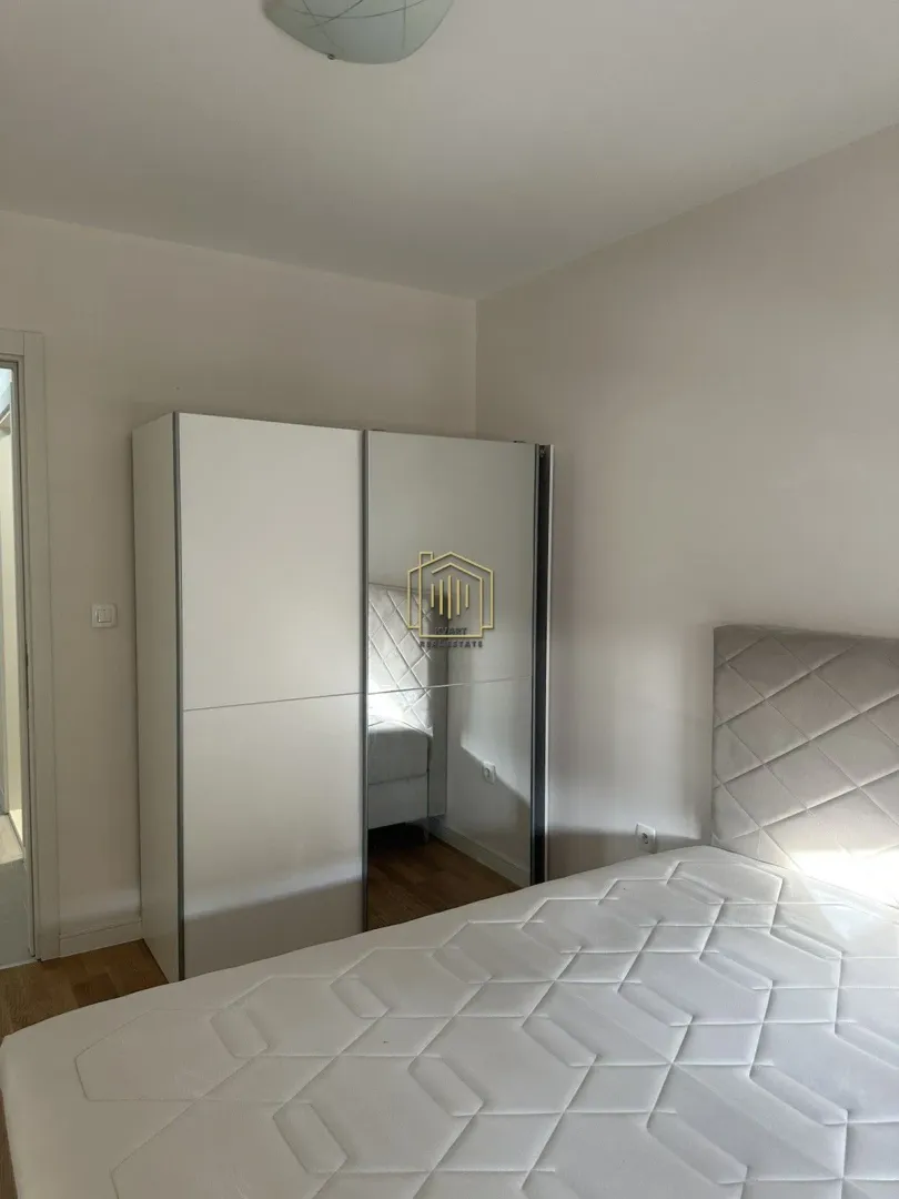 Furnished bedroom with a bed and a large wardrobe.