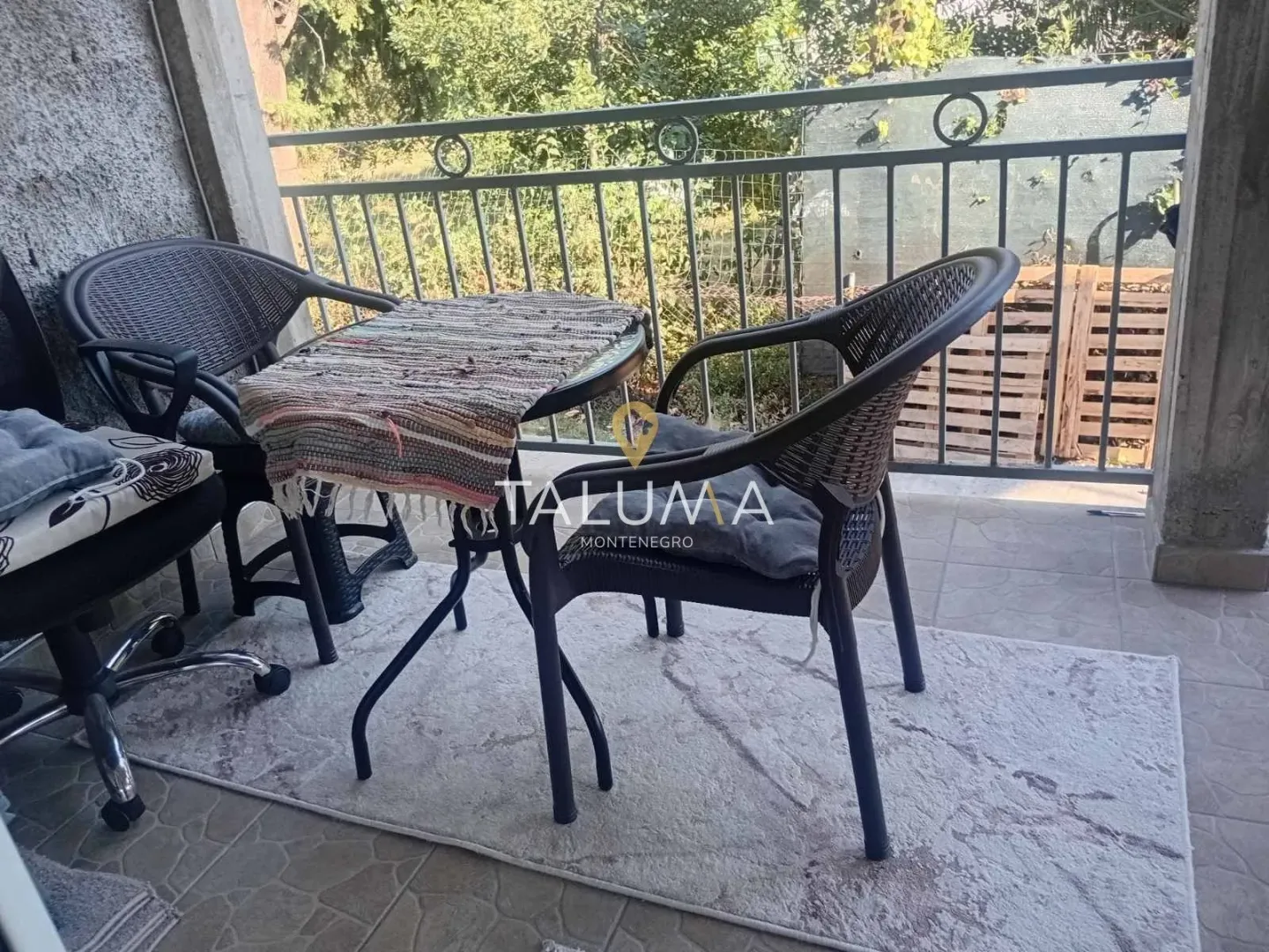 Furnished terrace with a table, chairs, and metal railing.