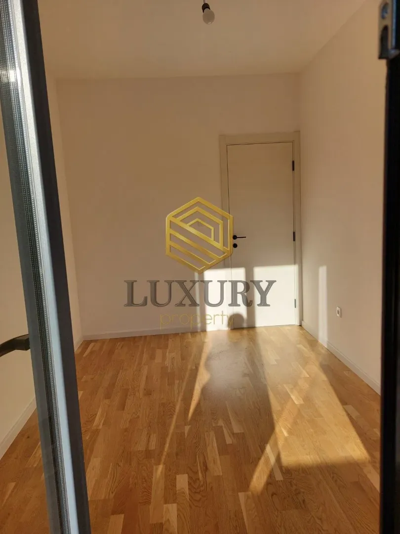 Empty room with parquet flooring and a closed door.