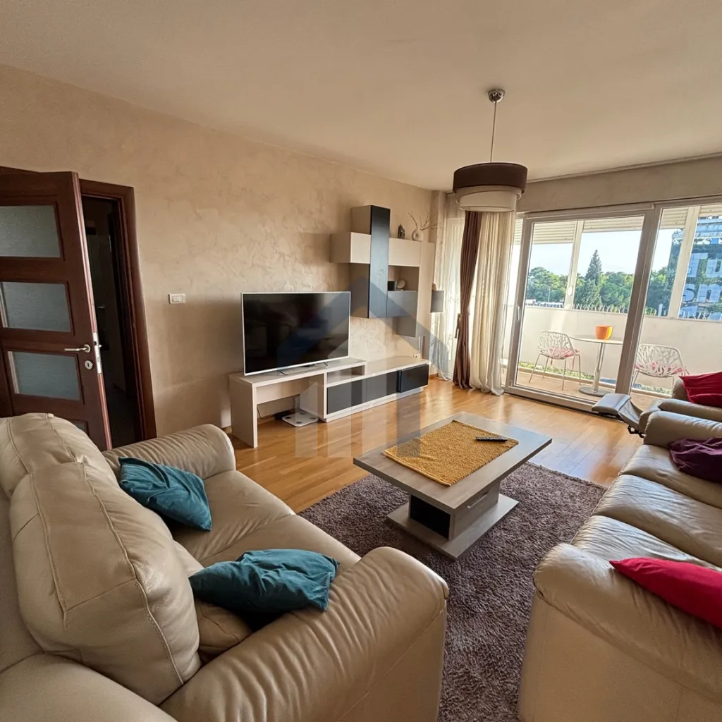 Spacious living room with sofa set and terrace access.