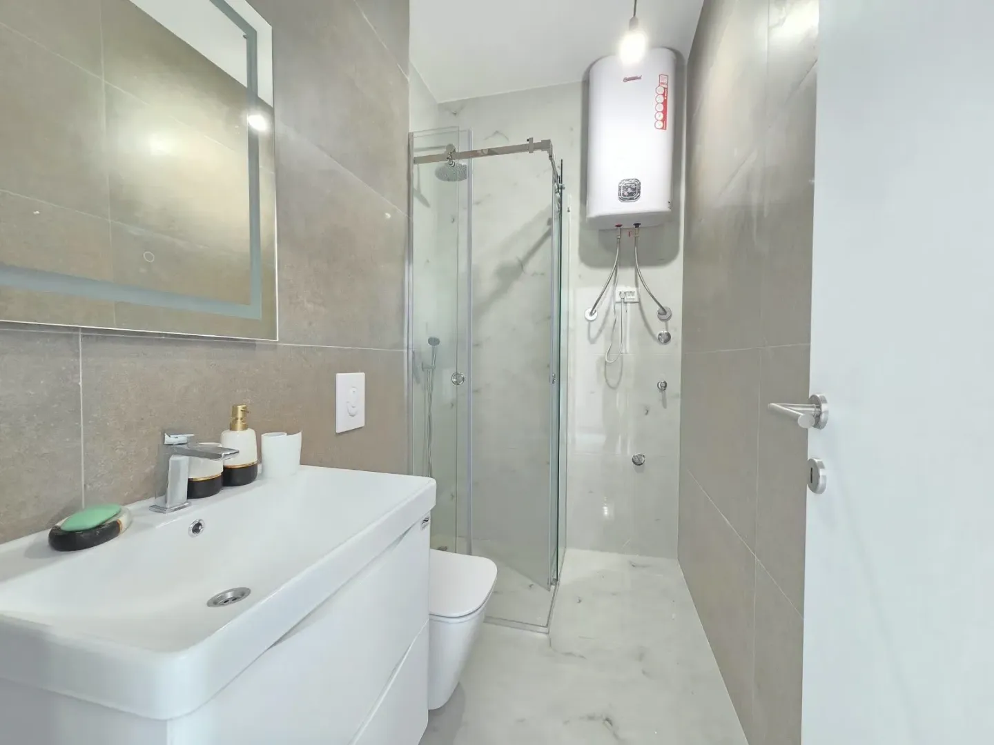 Modernly equipped bathroom with a shower cabin and washbasin.