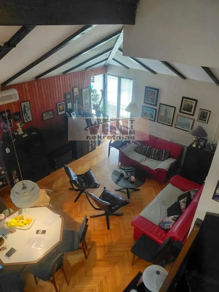 High-angle view of a spacious living room with a seating set and a dining table.