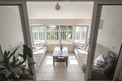 An enclosed terrace featuring a seating area and a small table. - image 2