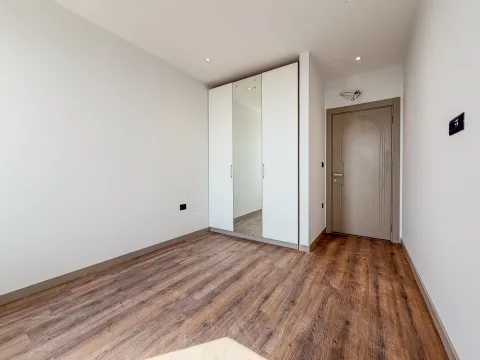 Prazna soba sa bijelim ormarom i drvenim podom. - image 17