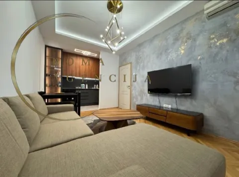 Modern living room with a sofa and a dining area in the background. - image 2
